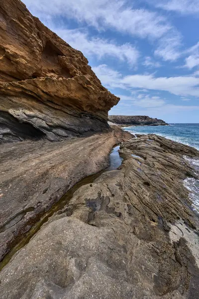Tenerife 'deki Playa de Montana Amarilla' da okyanusun üzerindeki volkanik kayalıklar.