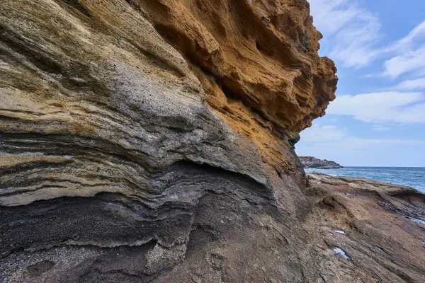Tenerife 'deki Playa de Montana Amarilla' da okyanusun üzerindeki volkanik kayalıklar.