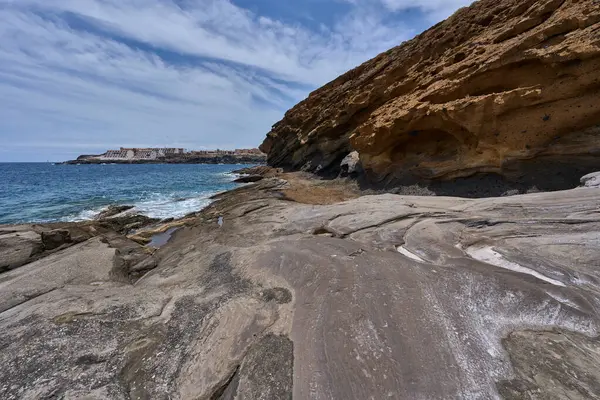 Tenerife 'deki Playa de Montana Amarilla' da okyanusun üzerindeki volkanik kayalıklar.