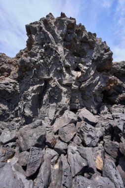 Tenerife 'deki Playa de Montana Amarilla' da okyanus kenarında aşınmış delikleri olan yıpranmış volkanik kayalara yakın çekim