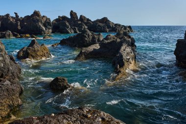 Volkanik kaya oluşumları Tenerife kıyısındaki La Vaca yakınlarındaki Charco El Diablo 'da denizden yükseliyor.