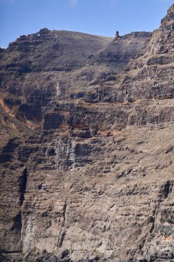 Los Gigantes 'teki dikey yamaç yüzeyinin detaylı görüntüsü katmanlanmış volkanik kaya katmanları ve aşınma şekillerini gösteriyor. 