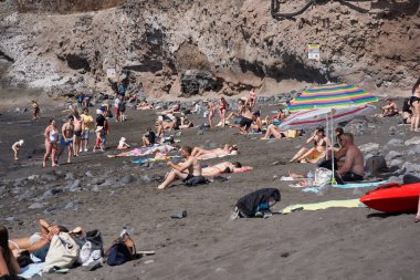 Playa de los Guios, güneşlenenlerle, yüzücülerle ve Los Gigantes 'in aşağısındaki volkanik plajın keyfini çıkaran ailelerle doluydu.