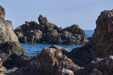 Volkanik kaya oluşumları Tenerife kıyısındaki La Vaca yakınlarındaki Charco El Diablo 'da denizden yükseliyor.