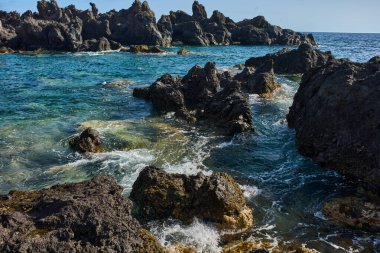 Volkanik kaya oluşumları Tenerife kıyısındaki La Vaca yakınlarındaki Charco El Diablo 'da denizden yükseliyor.
