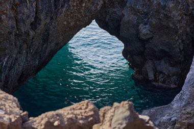 Charco la Vaca 'da volkanik kaya kemeri. Açılıştan görülebilen canlı turkuaz deniz.