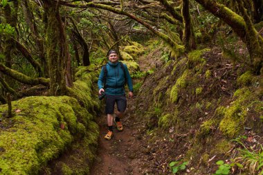 Sırt çantalı ve kameralı doğa fotoğrafçısı Tenerife 'deki Anaga ormanında yürüyüş ve çekim yapıyor.