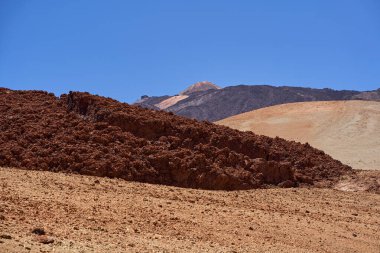 Teide Dağı Zirvesi ve Cablecar İstasyonu berrak bir yaz gökyüzünün altında pürüzsüz karanlık lav tarlalarının arkasında görüldü