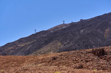 Teide Stratovolcano 'nun üst yamaçlarındaki La Rambleta istasyonuna yaklaşan kablo araba açık bir yaz gökyüzünün altında.