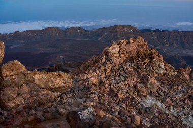 Gün batımından sonraki mavi saatte La Rambleta ve Pico del Teide 'nin kayalık kenarındaki uzak kalderaya bakın.