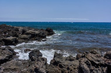 Dalgalar Tenerife Adası 'ndaki Malpais de Guimar kıyısı boyunca volkanik kayalara çarpıyor.