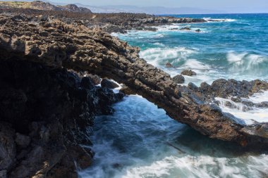 Volkanik deniz kemeri. Dalgalar çarpıyor ve su Tenerife kıyılarında akıyor.