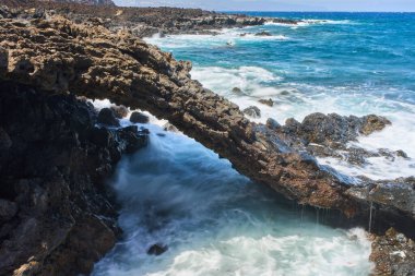 Volkanik deniz kemeri. Dalgalar çarpıyor ve su Tenerife kıyılarında akıyor.