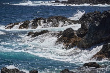 Dalgalar Tenerife Adası 'ndaki Malpais de Guimar kıyısı boyunca volkanik kayalara çarpıyor.