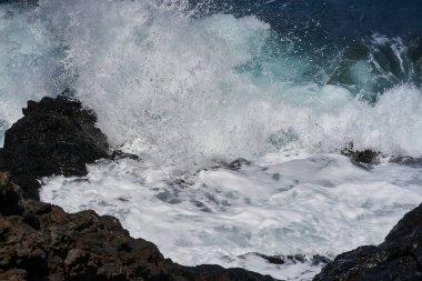 Dalgalar Tenerife Adası 'ndaki Malpais de Guimar kıyısı boyunca volkanik kayalara çarpıyor.