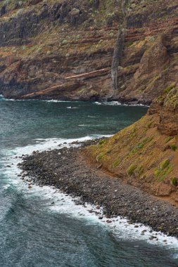 Anaga, Tenerife 'deki volkanik kıyı kayalıkları Atlantik kıyısı boyunca katmanlı katmanlar ve deniz mağaraları bulutlu gökyüzünün altında.