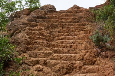 Tenerife 'nin Anaga bölgesinde eski bir patika boyunca kırmızımsı kayalara oyulmuş yıpranmış volkanik adımlar. 