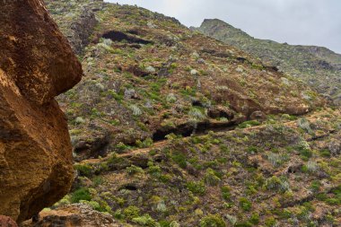 Anaga Tenerife 'deki aşınmış uçurumun aşağısında dönen volkanik yol daralıyor.