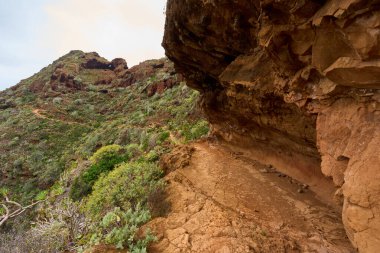 Anaga Tenerife 'deki aşınmış uçurumun aşağısında dönen volkanik yol daralıyor.