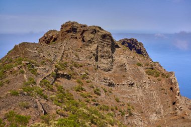 Atlantik kıyısındaki Teno dağlarındaki kahverengi kayalık yamaçların ve bitkilerin geniş manzarası