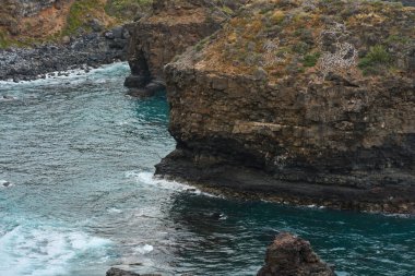 Volkanik kayalıkların ve turkuaz Atlantik dalgalarının ayrıntıları engebeli Tenerife kıyılarına çarpıyor.