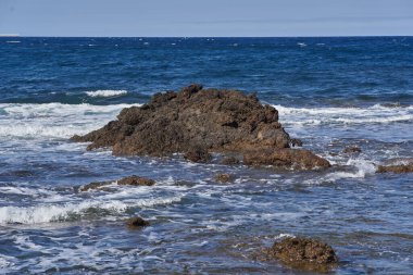 Volkanik kayalıkların ve engebeli Tenerife kıyılarına çarpan mavi Atlantik dalgalarının ayrıntıları
