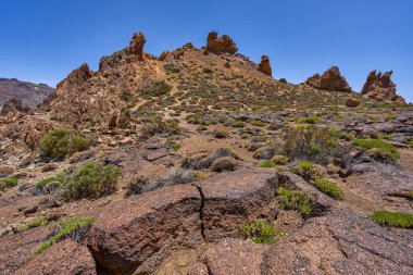 Volkanik kaya oluşumları ve Roques de Garcia 'nın engebeli yamaçları Teide Ulusal Parkı' nda açık mavi gökyüzü altında