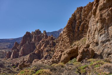 Volkanik kaya oluşumları ve Roques de Garcia 'nın engebeli yamaçları Teide Ulusal Parkı' nda açık mavi gökyüzü altında
