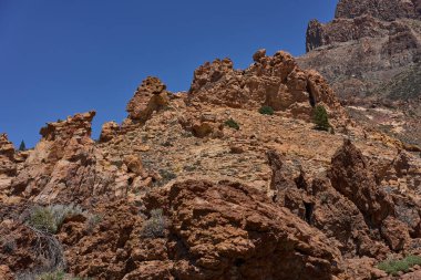 Kuru bitki örtüsü ve Teide Ulusal Parkı 'nda gevşek kayalarla çevrili aşınmış volkanik tuff kayalıkları.
