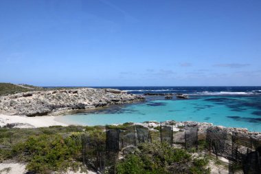 Batı Avustralya kıyılarındaki Rottnest Adası 'nın güzel kıyı görüntüsü. Temiz su, dalgalar, kireçtaşı kayaları ve bitki örtüsü gösteriliyor