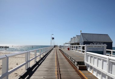 Busselton, Batı Avustralya 'daki tarihi iskele. Rıhtımı, treni, binaları, okyanusu ve mavi gökyüzünü gösteriyor