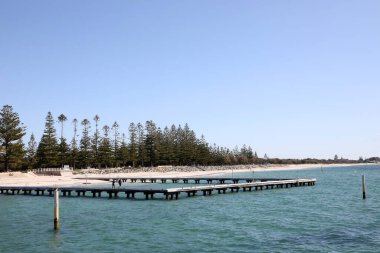Busselton, Batı Avustralya 'daki tarihi iskele. Rıhtımı, treni, binaları, okyanusu ve mavi gökyüzünü gösteriyor