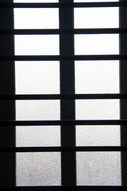 Silhouetted window frame fitted with frosted glass panes