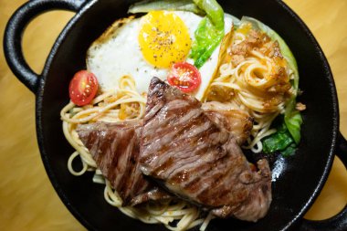 Evde kızarmış erişteli dilimlenmiş biftek.