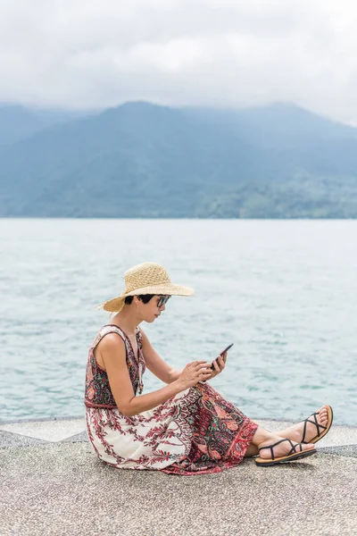 Viajando Mujer Asiática Con Sombrero Sentarse Muelle Usando Teléfono Celular —  Fotos de Stock