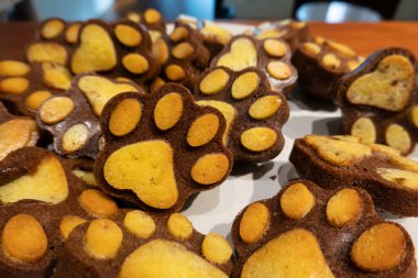 Paw ve ayak izi desenli kekler beyaz bir tabakta, eşsiz bir tasarım.