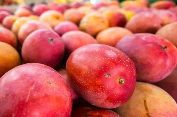 Stapel Von Mangofrüchten Leuchtend Roter Farbe Auf Dem Traditionellen Markt lizenzfreie Stockfotos