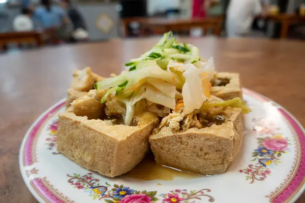 Plate of stinky tofu with pickled vegetables.