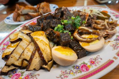 Dilimlenmiş tofu, haşlanmış et, haşlanmış yumurta, yeşil soğanla süslenmiş.