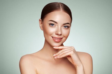 Temiz tenli güzel bir genç kadın portresi. Sağlıklı ciltli bir model, yakın portre. Kozmetik, güzellik ve kaplıca