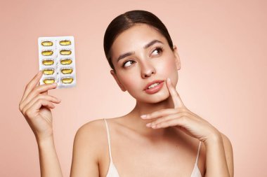 Vitaminler. Morina yağlı Omega-3 haplı mutlu güzel kıza yakın çekim. Beslenmek. D vitamini, E vitamini, balık yağı kapsülleri. Sağlıklı yaşam tarzı. Spor, Diyet Konsepti