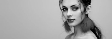 Mükemmel makyajlı esmer kız. Kıvırcık saçlı güzel bir model kadın. Bakım ve güzellik ürünleri. Saçları örgülü bir kadın. Mücevherleri olan bir model. Siyah beyaz fotoğraf