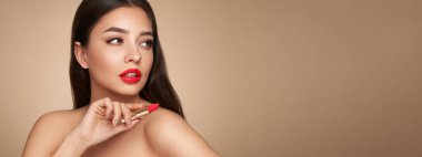 Ruj süren genç ve güzel bir kadın. Sağlıklı ciltli bir model, yakın portre. Kozmetik, güzellik ve kaplıca