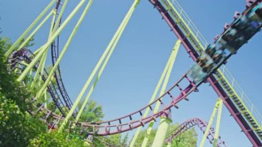 Mavi gökyüzüne karşı lunapark treni. Lunaparktaki lunaparkta hız treni. Eğlence parkında neşeli eğlenceler.