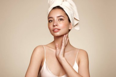 Gözlerinde kozmetik bantlarla gülümseyen güzel bir kadın. Göz çevresindeki cilt bakımı kozmetik prosedürleri. Mükemmel sağlıklı yüz derisi.