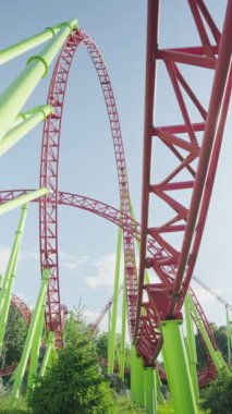 Mavi gökyüzüne karşı lunapark treni. Lunaparktaki lunaparkta hız treni. Eğlence parkında keyifli eğlenceler. Dikey video