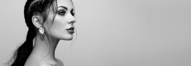 Mükemmel makyajlı esmer kız. Kıvırcık saçlı güzel bir model kadın. Bakım ve güzellik ürünleri. Saçları örgülü bir kadın. Mücevherleri olan bir model. Siyah beyaz fotoğraf