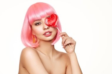 Pembe saçlı güzel bir model portresi. Bob kısa saç kesimi. Kalp şeklinde lolipopu olan güzel, çekici bir kız.