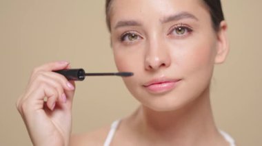 Makyaj fırçasıyla kirpiklerine siyah rimel süren güzel bir kadın. Kirpik uzantıları. Makyaj, kozmetik. Güzellik, cilt bakımı