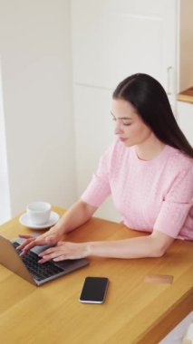 Genç, çekici bir kadın, kredi kartıyla dizüstü bilgisayarla online alışveriş yapıyor. E-ticaret, iş konsepti. Serbest, uzak çalışma